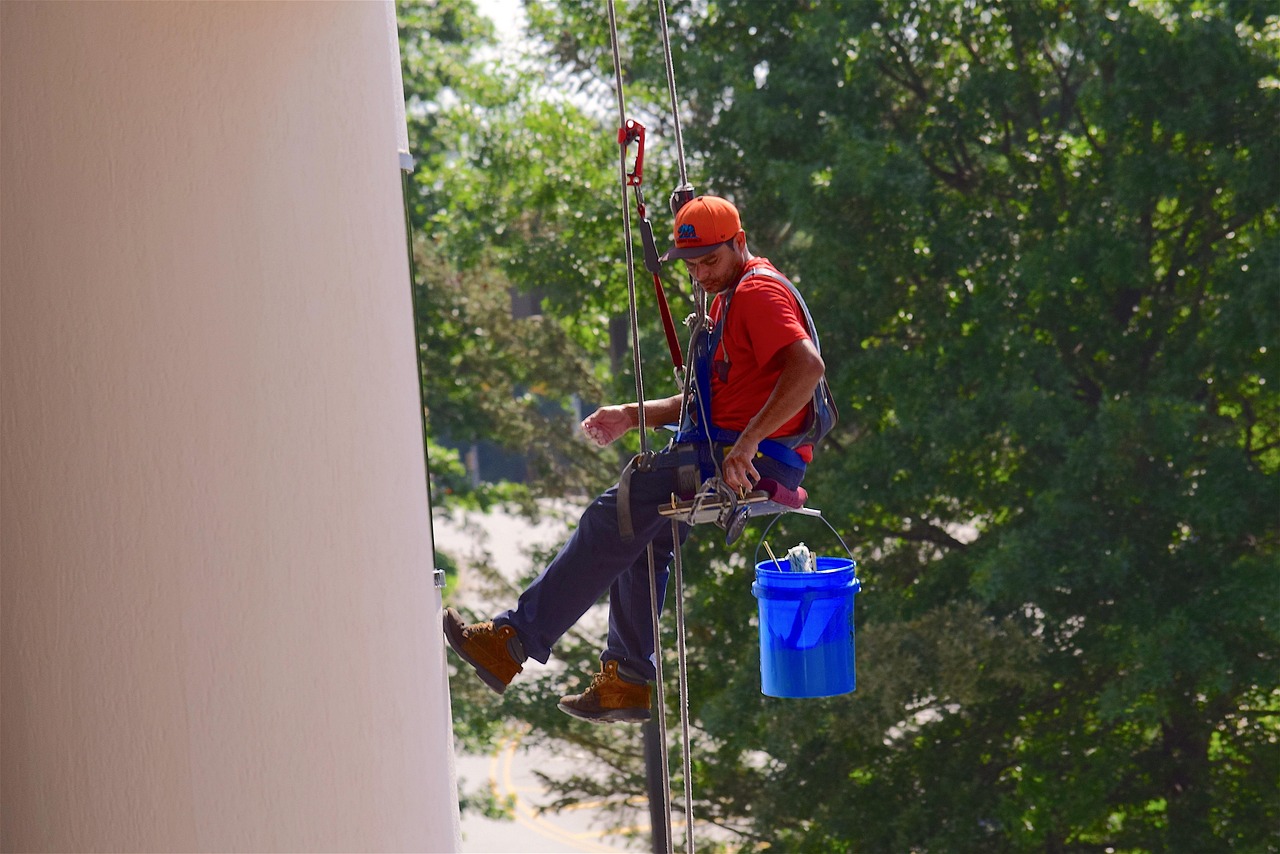 A window washer working with a squeegee and pole